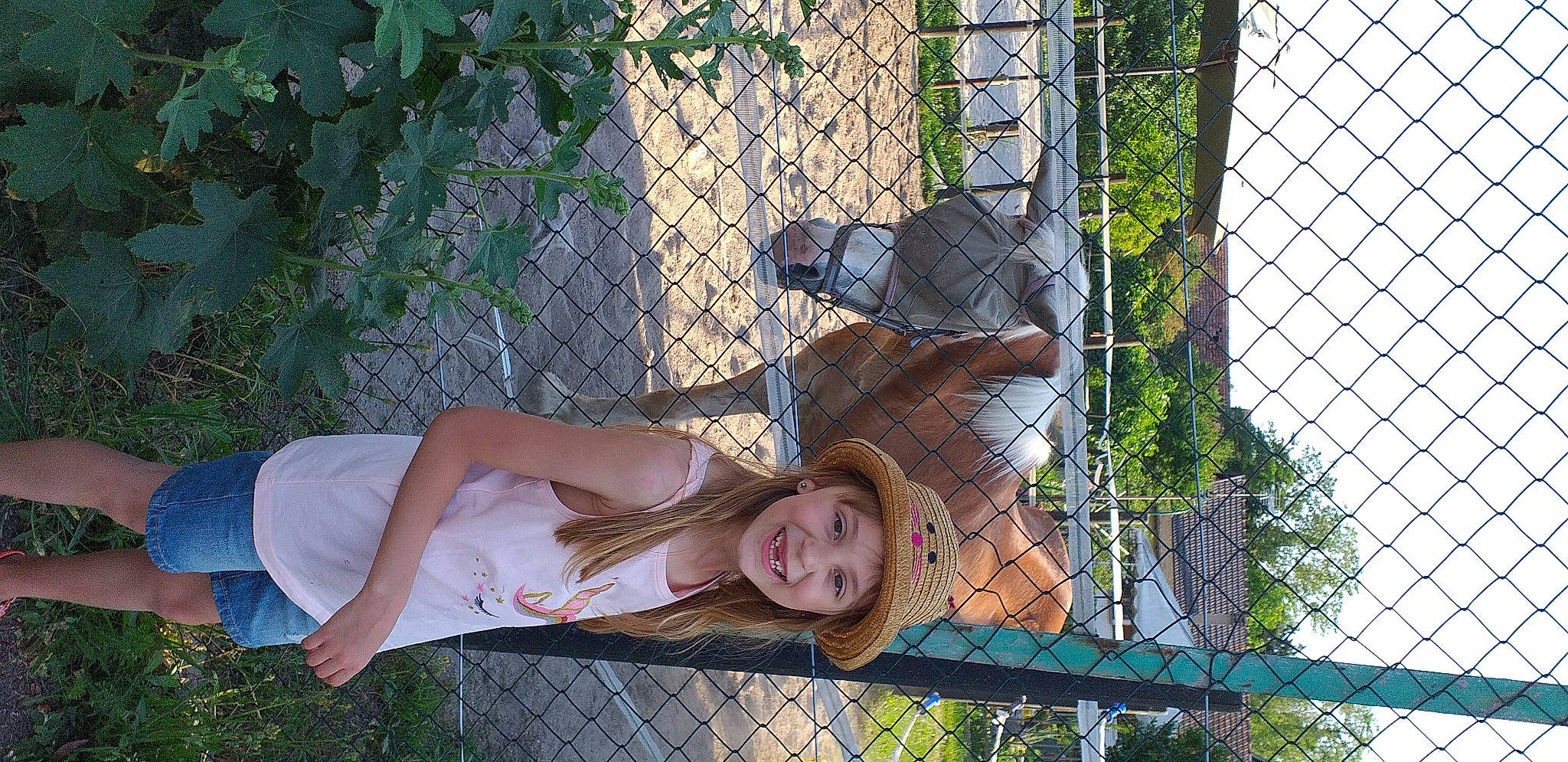 Mélina a rejoint le concours — aidez-le/la à gagner de superbes lots ! botany, chain_link_fencing, facial_expression, fawn, fence, fun, garden, grass, happy, headwear, joy, leisure, mammal, mesh, people_in_nature, person, plant, smile, thigh, tree