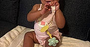Jae'Onti is registered to the contest to win money with this photo: accessory, baby, blanket, bow, child, clothing, couch, cute, face, feet, girl, hand, happy, indoors, infant, pacifier, playful, sitting, smiling, toy