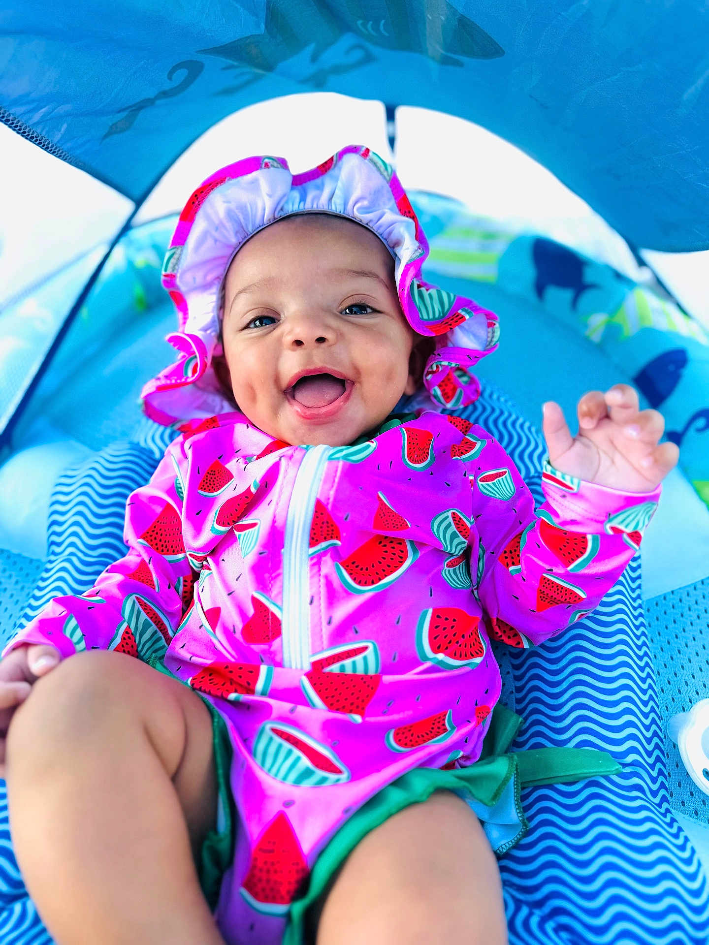 Isla joined the competition — help win amazing prizes! baby, child, smile, happy, swimsuit, bonnet, watermelon_pattern, tent, blue, fabric, infant, playtime, cute, summer, outdoor_gear, colorful, clothing, cheerful, portrait, person