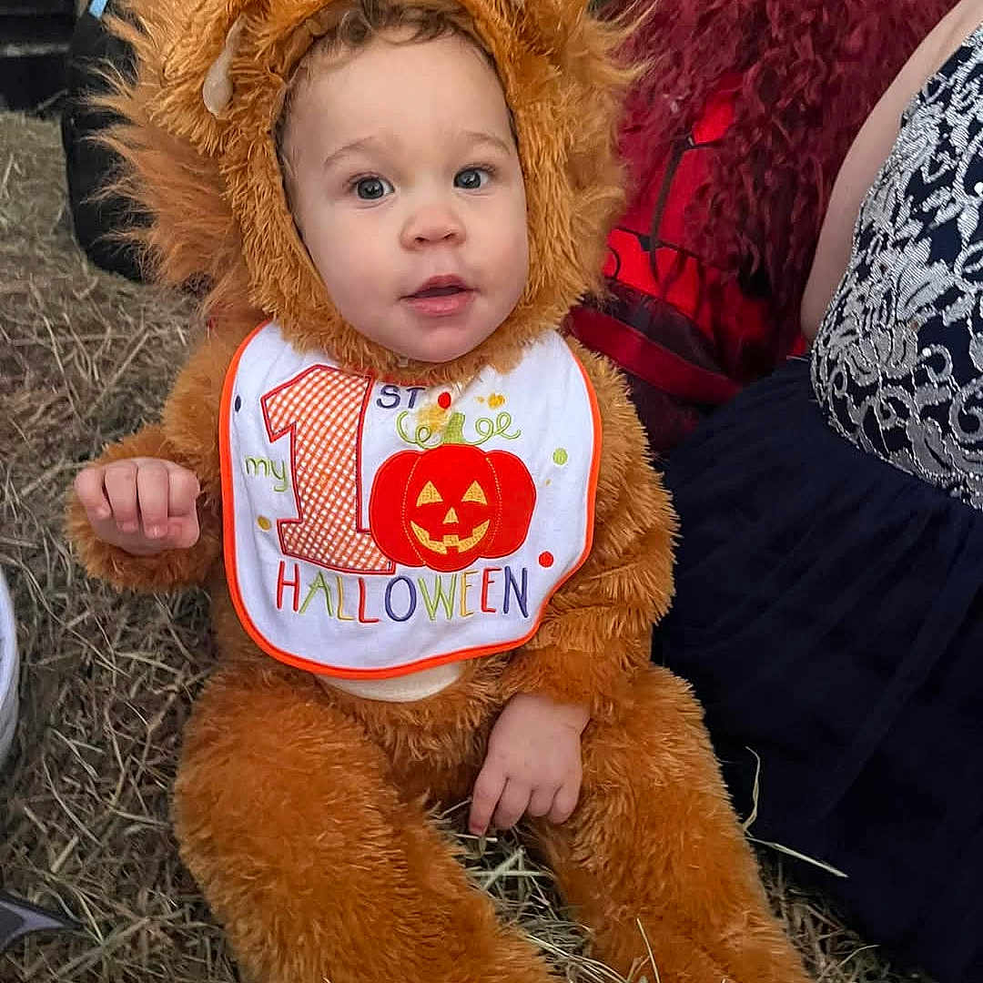 Caylixx joined the competition — help win amazing prizes! animal_costume, baby, bib, celebration, child, childrens_clothing, costume, cute, festive, fun, halloween, hay, lion, outdoor, person, portrait, pumpkin, seasonal, smile, toddler