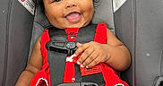 Amaia is registered to the contest to win money with this photo: baby, child, car_seat, red_dress, smile, happy, cute, hair_bows, infant, seat_belt, straps, black_hair, indoors, person, portrait, close_up, safety, car_safety, baby_girl, expression