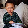 Ikana is registered to the contest to win money with this photo: child, toddler, smiling, pajamas, book, bed, indoor, happy, portrait, face, curly_hair, reading, cozy, plaid, person, young_child, cute, home, hands, leisure