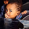 Ikana is registered to the contest to win money with this photo: child, car_seat, curly_hair, fingers, car_window, sunlight, portrait, seatbelt, interior, vehicle, face, person, young, two_children, shadow, closeup, casual, expression, indoor, candid