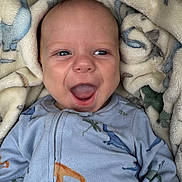 Niklaus joined the competition — help win amazing prizes! baby, infant, smiling, happy, blue_eyes, blanket, dinosaur_pattern, onesie, clothing, cute, portrait, child, cozy, soft, warm, face, mouth_open, lying_down, indoors, closeup