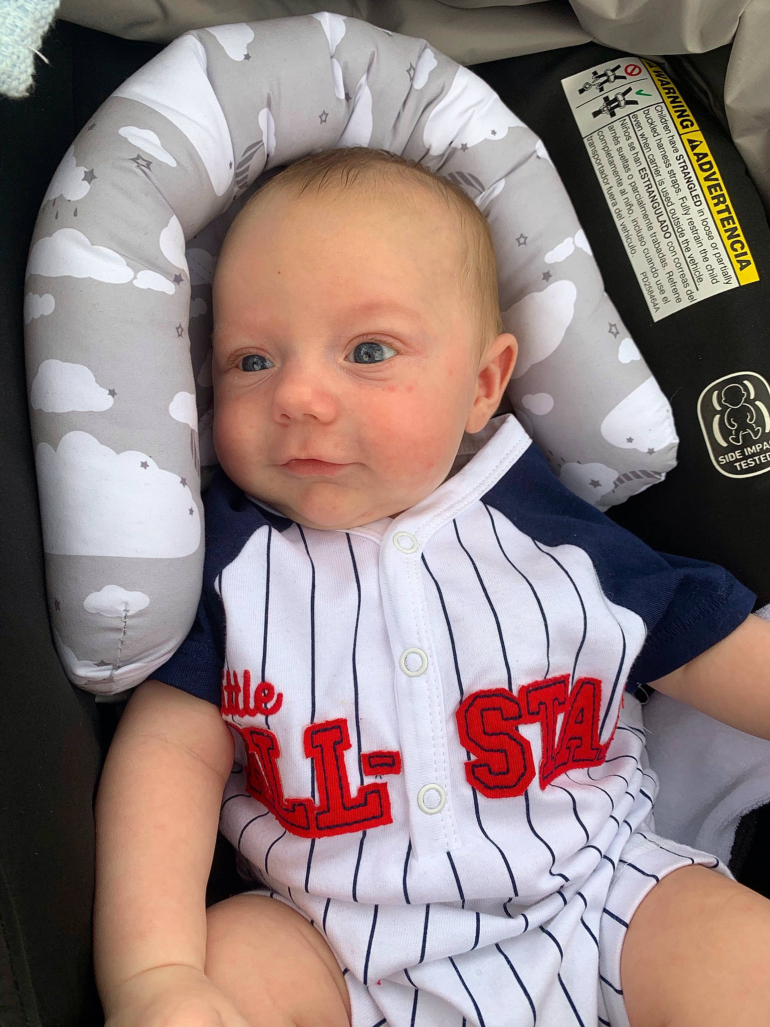 Joel is registered to the contest to win money with this photo: arm, baby, baby_toddler_clothing, baseball_uniform, car_seat, cheek, child, chin, comfort, elbow, gesture, happy, jersey, person, sitting, sleeve, sports_uniform, sportswear, t_shirt, toddler