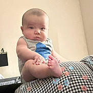 Cj joined the competition — help win amazing prizes! baby, child, infant, sitting, portrait, face, eyes, clothing, shirt, bare_feet, blanket, floral_pattern, checkered_pattern, bedroom, indoor, wall, furniture, looking_at_camera, cute, photography