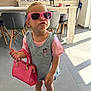 attitude, chairs, child, cute, denim_overall, fashion, floor_tiles, handbag, indoor, kitchen, modern, person, pink_shirt, pink_sunglasses, playful, pout, sneakers, sunlight, table, toddler