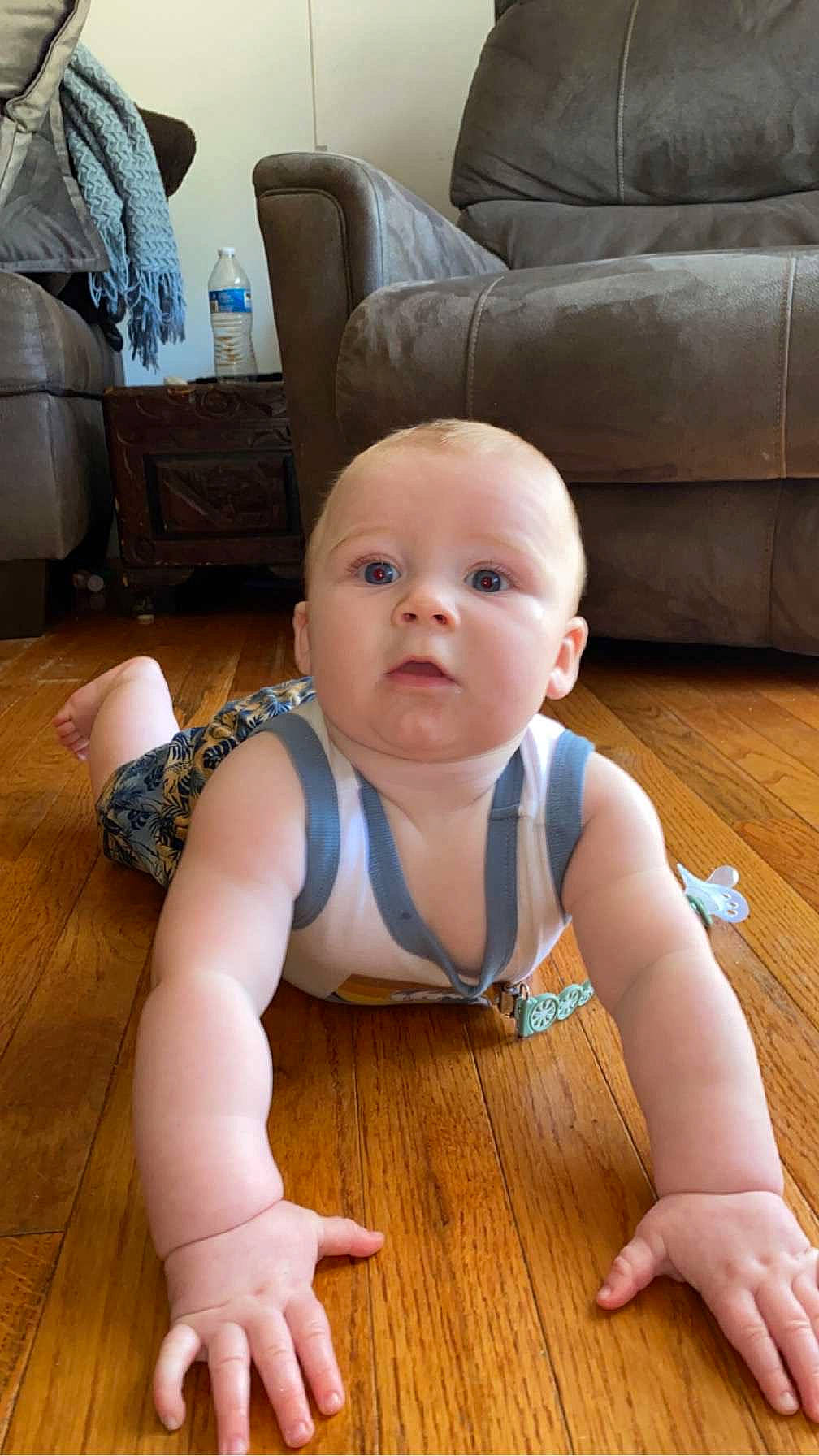 Westin is registered to the contest to win money with this photo: baby, baby_toddler_clothing, cheek, chest, comfort, couch, crawling, floor, flooring, foot, happy, hardwood, human_leg, joint, knee, person, skin, surprise, toddler, trunk