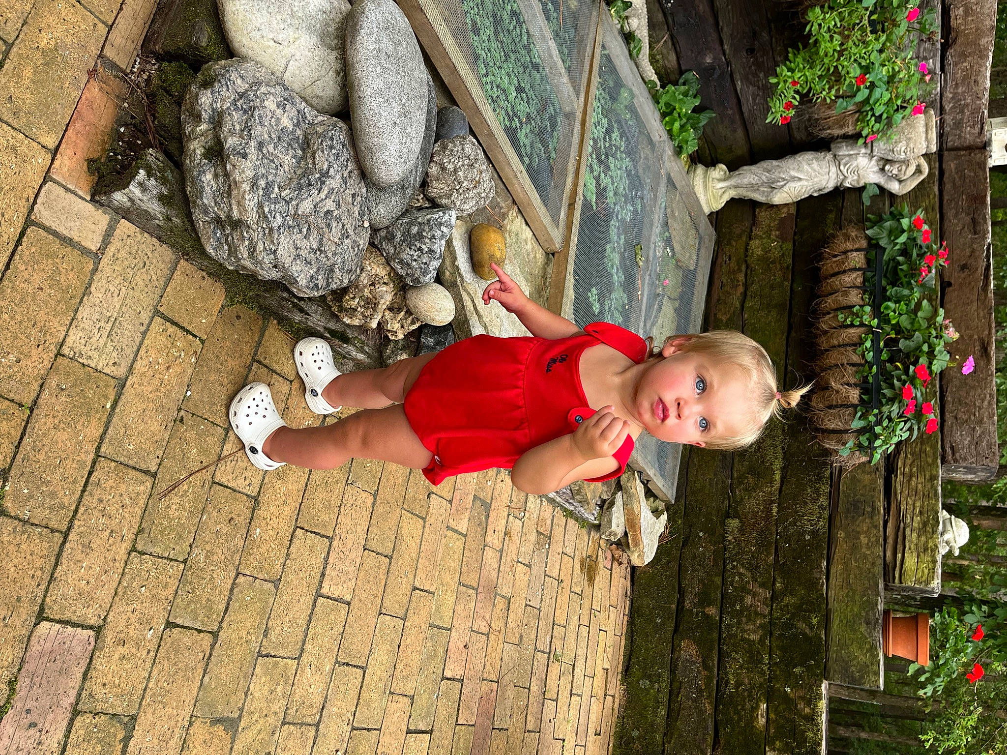 Indigo is registered to the contest to win money with this photo: baby, child, cobblestone, flooring, flower, fun, grass, happy, human_leg, leisure, people_in_nature, person, plant, rock, sandal, temple, toddler, tree, trunk, vacation