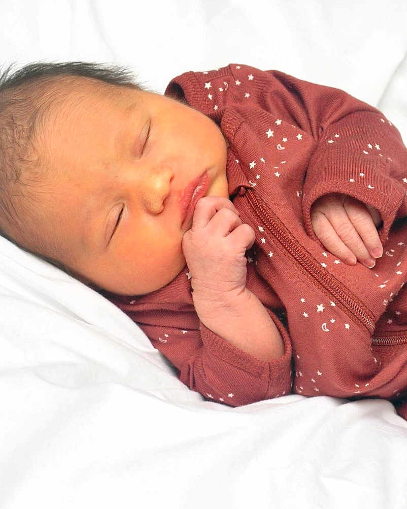 Cheyanne is registered to the contest to win money with this photo: newborn, baby, sleeping, infant, onesie, maroon, stars, moon, hand, face, soft, blanket, cozy, peaceful, closeup, portrait, child, resting, cute, indoors