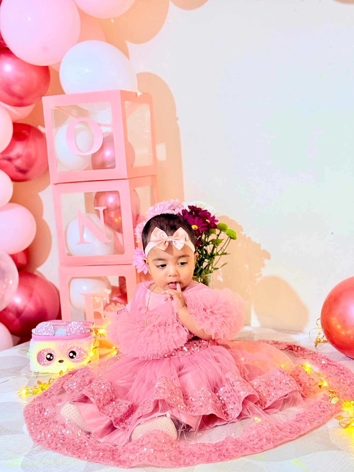 Arafah joined the competition — help win amazing prizes! baby, child, pink_dress, headband, balloons, birthday, celebration, fairy_lights, plush_purse, flowers, decorations, tulle, ruffles, seated, indoor, cute, portrait, festive, adorable, happy