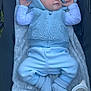 baby, sleeping, blue_clothing, hooded_vest, fleece, blanket, stroller, baby_bottle, plush_toy, knitted_booties, infant, cozy, cute, peaceful, soft_texture, resting, child, newborn, baby_accessories, lying_down