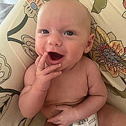 Oliver joined the competition — help win amazing prizes! baby, infant, smiling, happy, hand, face, skin, diaper, sitting, cushion, pattern, floral, comfort, cute, child, portrait, indoors, young, expression, playful