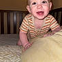 Damon joined the competition — help win amazing prizes! baby, child, crib, pillow, bed, crawling, smiling, striped_clothing, onesie, indoor, happy, young_child, face, hands, mattress, light_skin, short_hair, room, head, infant