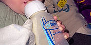 Damon joined the competition — help win amazing prizes! baby, bottle, drinking, blanket, infant, hand, clothing, face, eyes, milk, indoors, person, closeup, cute, feeding, child, young, soft, comfort, rest