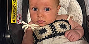Georgia is registered to the contest to win money with this photo: baby, child, car_seat, blanket, crochet, clothing, face, person, infant, blue_eyes, skin, hand, earrings, cute, adorable, indoor, portrait, closeup, seat, sitting