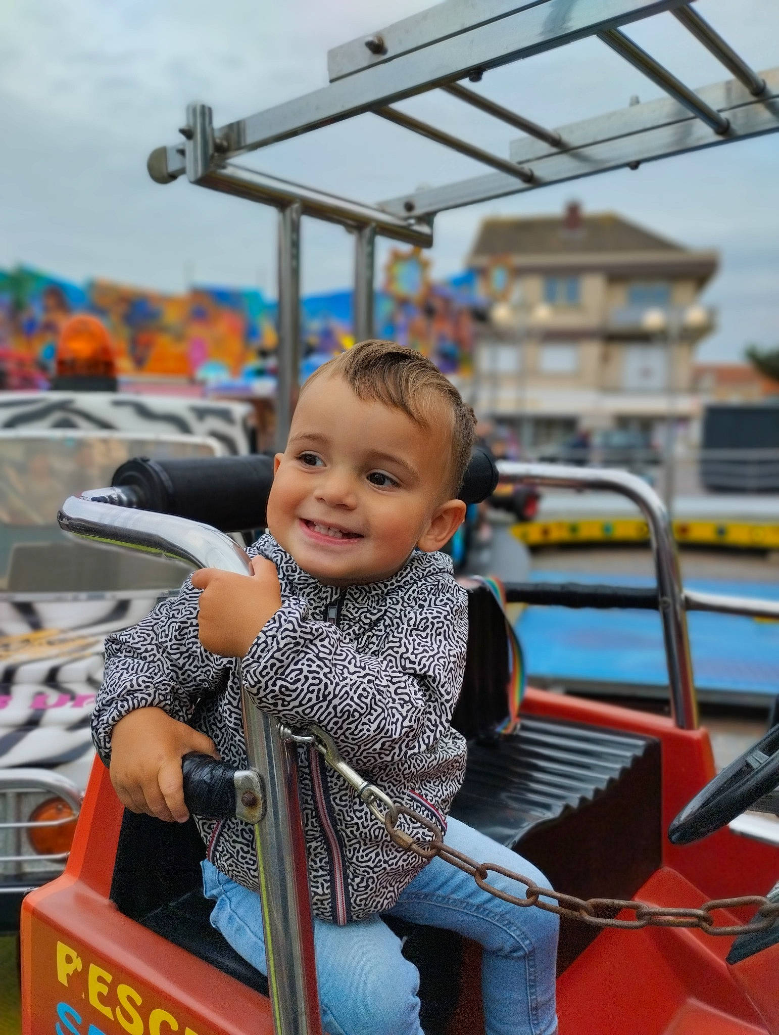 Samuël a rejoint le concours — aidez-le/la à gagner de superbes lots ! amusement_park, amusement_ride, child, city, fun, happy, joy, leisure, mode_of_transport, motor_vehicle, nonbuilding_structure, person, recreation, sitting, skin, sky, smile, toddler, tourism, transport