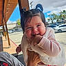 baby, blue_sky, car, child, clothing, clouds, cute, face, hand, hearts, holding, outdoor, person, pigtails, pink, smiling, street, sunlight, tattoo, vest