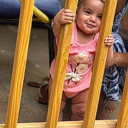 Heily joined the competition — help win amazing prizes! baby, child, girl, pink_clothing, headband, wooden_slats, smiling, holding, standing, adult_hand, indoor, floor, footwear, support, happy, cute, portrait, person, playful, curious