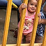 baby, child, girl, pink_clothing, headband, wooden_slats, smiling, holding, standing, adult_hand, indoor, floor, footwear, support, happy, cute, portrait, person, playful, curious