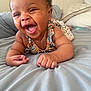 baby, smiling, happy, infant, bed, pillow, blanket, indoors, child, person, cute, clothing, floral, skin, face, hands, lying_down, expression, joy, toddler