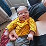Lyam participe au concours pour gagner de l'argent avec cette photo : baby, smiling, child, yellow_shirt, adult, holding, indoor, natural_light, happy, portrait, person, window, door, home, casual_clothing, floor, carpet, hand, face, candid