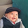 baby, smiling, face, child, vest, cap, hat, clothing, happy, infant, portrait, cute, sitting, indoor, couch, pillow, person, headwear, fashion, young