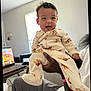 Dakotah joined the competition — help win amazing prizes! baby, child, smiling, pajamas, animal_print, indoor, person, hand, adult_hand, laptop, table, window, room, curtain, furniture, joyful, cute, portrait, holding, cozy