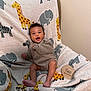 baby, infant, two_months, smiling, cute, blanket, animal_pattern, giraffe, elephant, toddler, clothing, sitting, indoor, happy, child, portrait, furniture, cozy, feet, cute_expression