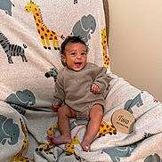 Dakotah joined the competition — help win amazing prizes! baby, infant, smiling, sitting, blanket, animal_pattern, giraffe, elephant, clothing, indoor, happy, cute, child, portrait, two_months, cozy, young_child, person, fabric, soft