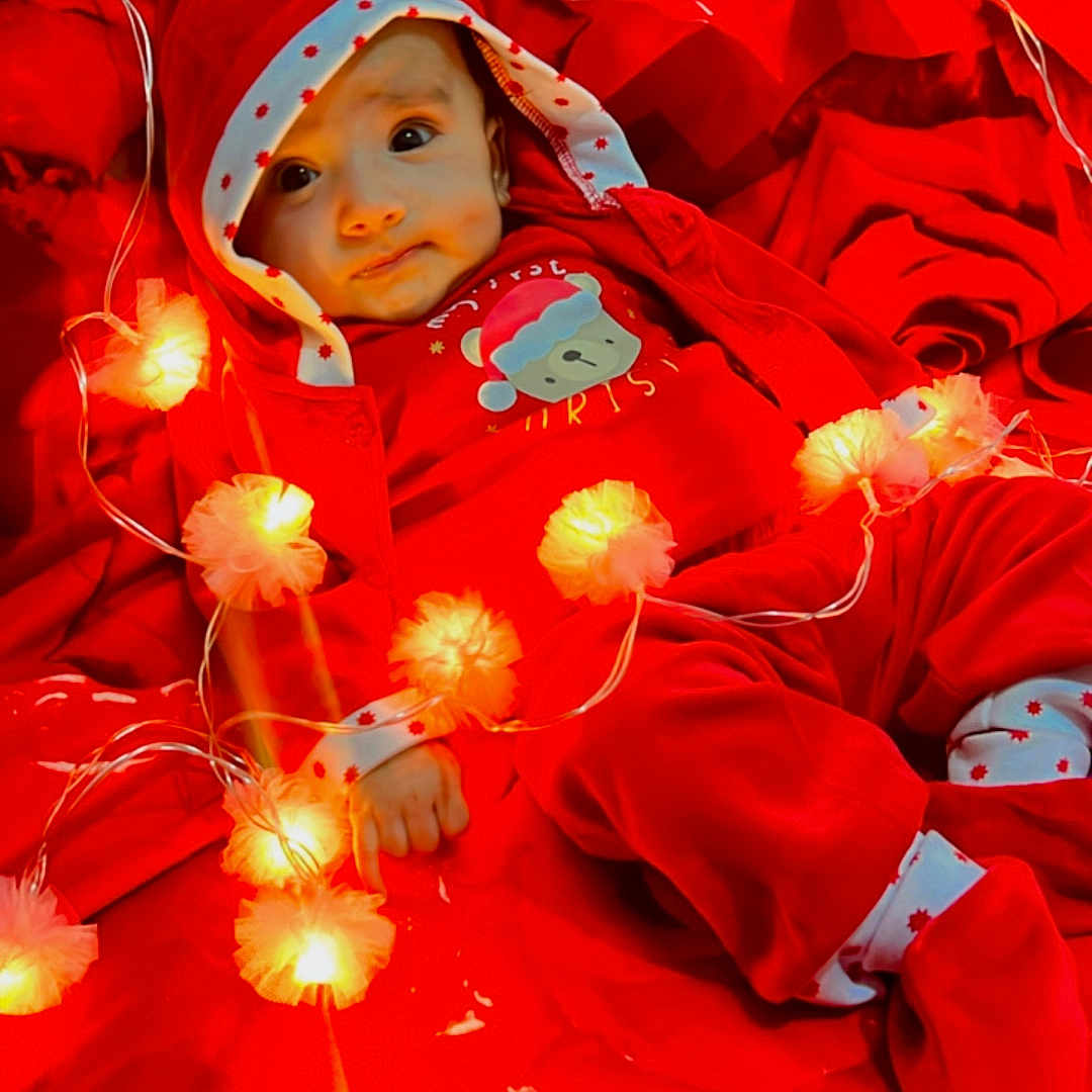 Ravika is registered to the contest to win money with this photo: baby, blanket, clothing, coat, costume, dress, face, festival, flower, happy, hat, head, hood, light, lighting, person, photography, plant, portrait, smile