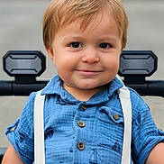 Malakai joined the competition — help win amazing prizes! toddler, child, smile, blue_shirt, suspenders, stroller, outdoor, face, buttoned_shirt, short_sleeves, light_brown_hair, happy, portrait, baby, young_child, cute, person, seatbelt, closeup, casual_clothing