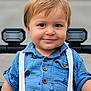 toddler, child, smile, blue_shirt, suspenders, stroller, outdoor, face, buttoned_shirt, short_sleeves, light_brown_hair, happy, portrait, baby, young_child, cute, person, seatbelt, closeup, casual_clothing