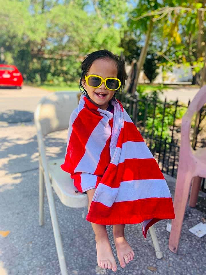 Melani is registered to the contest to win money with this photo: bag, dress, eyewear, glasses, goggles, grass, joy, leisure, luggage_and_bags, neck, person, plaid, plant, public_space, sleeve, street_fashion, summer, sunglasses, tartan, tree