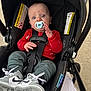 baby, pacifier, car_seat, sneakers, red_sweater, green_pants, child, infant, seatbelt, footwear, person, outdoor, curious, wide_eyes, black_car_seat, clothing, cute, sitting, safety, infant_boy