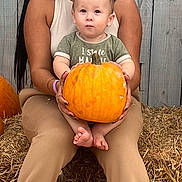 Julius joined the competition — help win amazing prizes! woman, baby, pumpkin, hay, autumn, smile, outdoor, fall, clothing, sneakers, wooden_fence, person, child, nature, seasonal, portrait, holding, sitting, happy, family