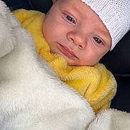 Keyron participe au concours pour gagner de l'argent avec cette photo : baby, infant, blanket, knit_hat, yellow_clothing, face, portrait, cozy, soft_texture, cute, child, wrapped, sleepy, warm, closeup, indoor, comfort, cushion, car_seat, adorable