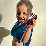 Nolan participe au concours pour gagner de l'argent avec cette photo : toddler, child, smiling, sunglasses, blue_shirt, bare_belly, short_hair, indoor, shadow, light, casual_clothing, happy, portrait, cute, playful, young_child, person, holding_object, fun, bright