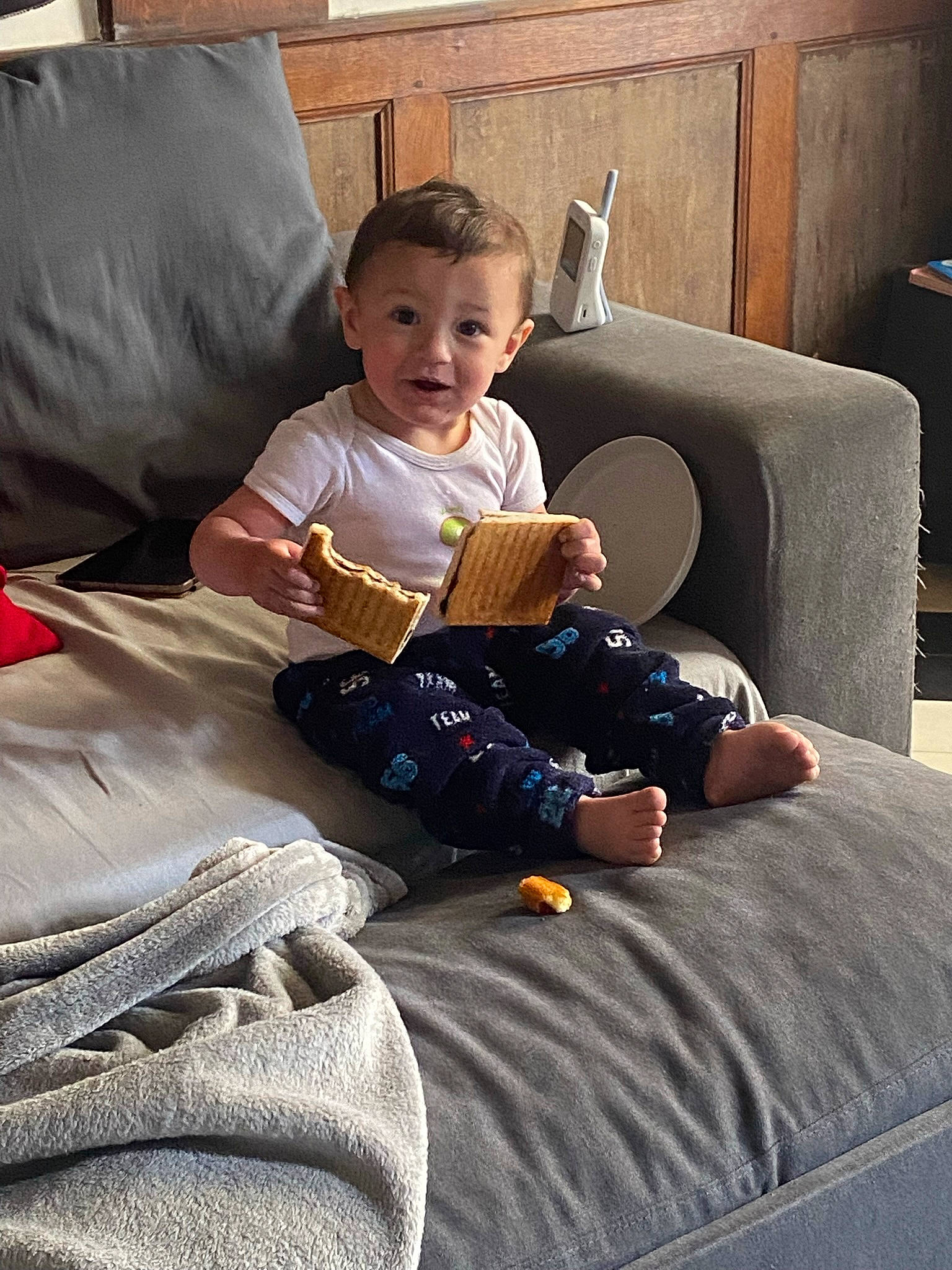 Marvin participe au concours pour gagner de l'argent avec cette photo : baby, child, comfort, couch, flooring, fun, hardwood, human_leg, lap, leisure, linens, living_room, person, picture_frame, room, sitting, smile, sneakers, t_shirt, toddler