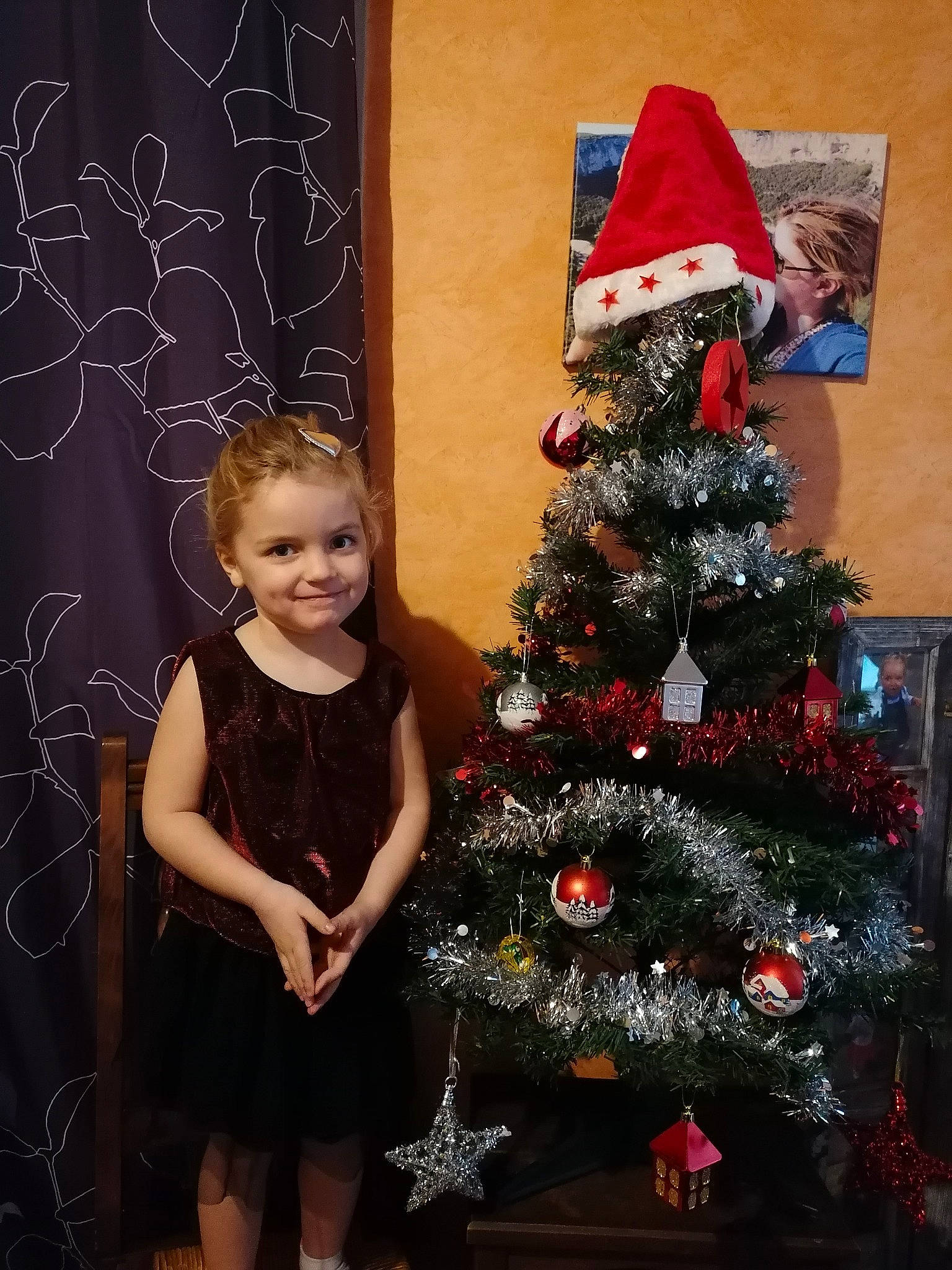 Noëlyne participe au concours pour gagner de l'argent avec cette photo : baby_toddler_clothing, blackboard, christmas, christmas_decoration, christmas_eve, christmas_ornament, christmas_tree, conifer, day_dress, dress, event, holiday, holiday_ornament, home, interior_design, joy, one_piece_garment, ornament, person, pine_family