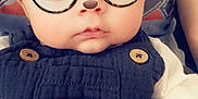 Aiden is registered to the contest to win money with this photo: baby, child, face, glasses, filter, bear_ears, blanket, clothing, cute, infant, portrait, person, indoor, soft_texture, button, eyewear, young_child, sitting, closeup, expression