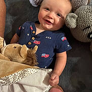 Beau joined the competition — help win amazing prizes! baby, blanket, blue_outfit, child, close_up, clothing, couch, cozy, elephant, flag_pattern, happy, indoors, infant, lion, portrait, sitting, smiling, stuffed_animal, toy, usa_shirt