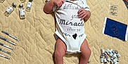 Asaiah joined the competition — help win amazing prizes! newborn, baby, infant, onesie, blanket, pregnancy_test, syringes, vaccine_vials, medical_supplies, floor, healthcare, child, person, lying_down, expression, clothing, cute, indoors, small, miracle