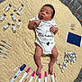newborn, baby, infant, onesie, blanket, pregnancy_test, syringes, vaccine_vials, medical_supplies, floor, healthcare, child, person, lying_down, expression, clothing, cute, indoors, small, miracle