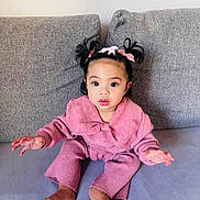 Tamarah Luna a rejoint le concours — aidez-le/la à gagner de superbes lots ! toddler, child, baby, pink_clothing, knitwear, couch, sofa, indoor, portrait, cute, curly_hair, ponytails, bows, sitting, expression, hands, face, eyes, socks, cozy