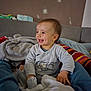 Liam participe au concours pour gagner de l'argent avec cette photo : baby, blanket, child, clothing, comfort, couch, cozy, cute, face, furniture, happy, home, indoor, person, playful, relaxed, sitting, smiling, soft, toddler