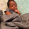 Dallas is registered to the contest to win money with this photo: baby, newborn, sleeping, blanket, couch, pillow, star_pattern, indoors, infant, peaceful, resting, cozy, clothing, face, hand, soft_texture, portrait, child, toddler, cute