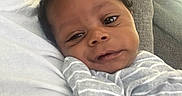 Dallas joined the competition — help win amazing prizes! baby, child, clothing, comfort, couch, cozy, cute, expression, face, gray, head, indoors, infant, person, portrait, resting, snuggle, striped, white, young