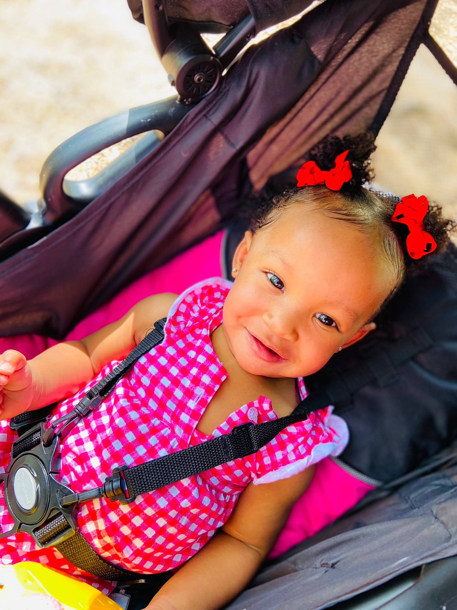 Alaura is registered to the contest to win money with this photo: auto_part, baby, baby_carriage, baby_products, baby_toddler_clothing, black_hair, child, fun, happy, joy, leisure, magenta, motor_vehicle, person, pink, red, sitting, skin, smile, steering_wheel
