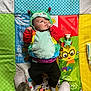 Nolan joined the competition — help win amazing prizes! baby, child, costume, caterpillar, play_mat, colorful, toy, socks, feet, indoor, infant, cute, lying_down, hand_on_mouth, looking_away, patterned_mat, red, green, blue, yellow